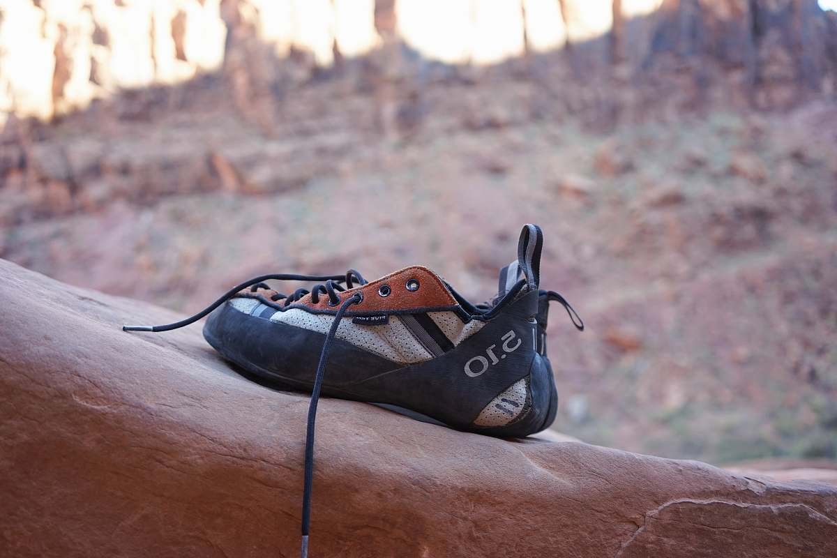 rock climbing black and white shoes place on rock formation clothing
